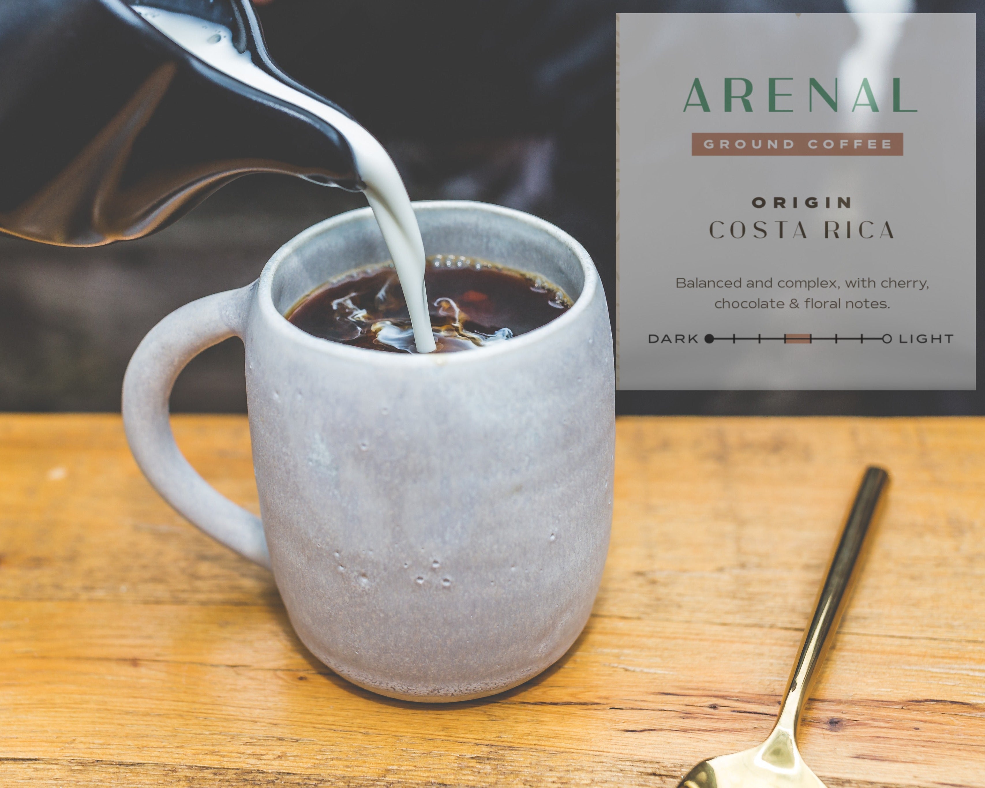 Coffee being poured into a mug with Arenal Costa Rica coffee packaging in the background.