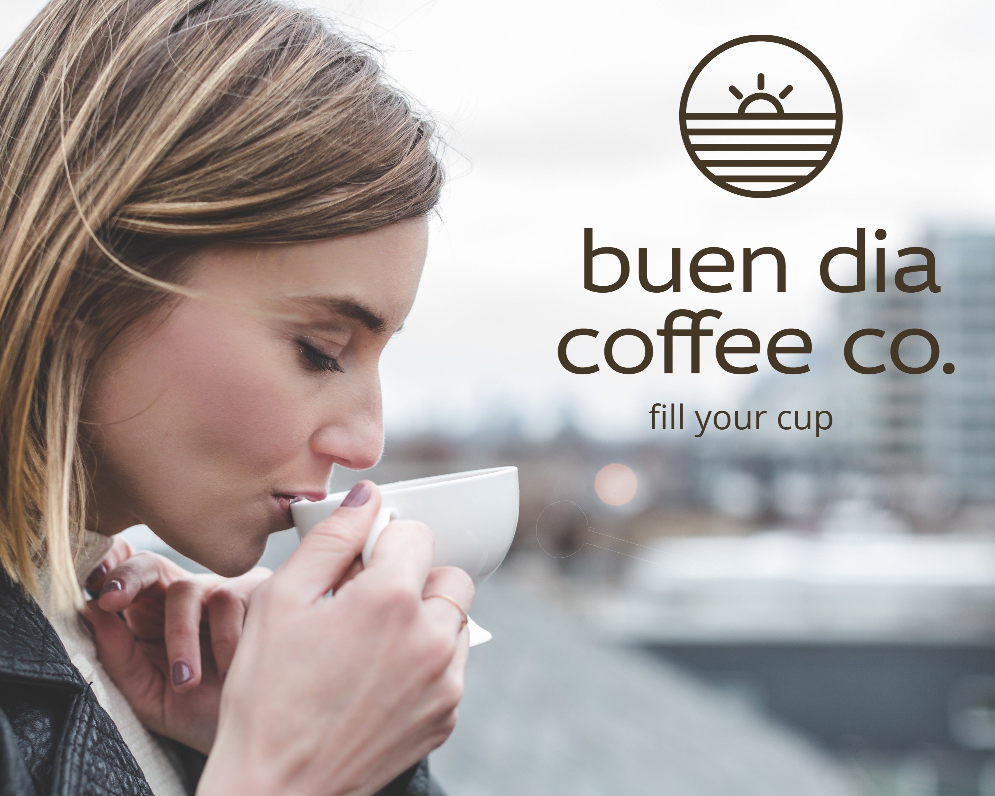 Woman drinking coffee with 'buen dia coffee co.' logo in the background